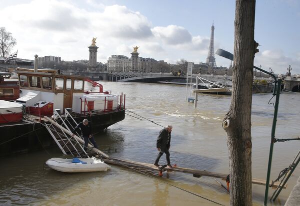 Житель Парижа идет по набережной реки Сена после сильного наводнения в окрестностях французской столицы - Sputnik Грузия