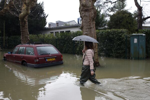 Жительница Вильнен-сюр-Сен (к западу от Парижа), идет по затопленной в результате наводнения улице. Франция пострадала от самых сильных за последние 50 лет проливных дождей. От наводнения также пострадали районы близ Парижа - Sputnik Грузия