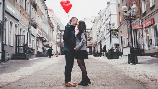 Влюбленная пара держит воздушные шарики в виде сердечек - Sputnik Грузия
