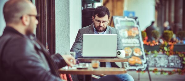 Мужчина работает на ноутбуке в одном из кафе в Тбилиси - Sputnik Грузия