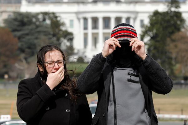 Туристы закрывают лица от сильного ветра у Белого дома в Вашингтоне - Sputnik Грузия
