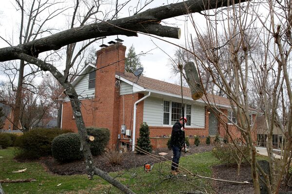 Рабочие убирают территорию вокруг частного дома в городе Кенсингтон в Мэриленде, где сильный ветер повалил деревья - Sputnik Грузия