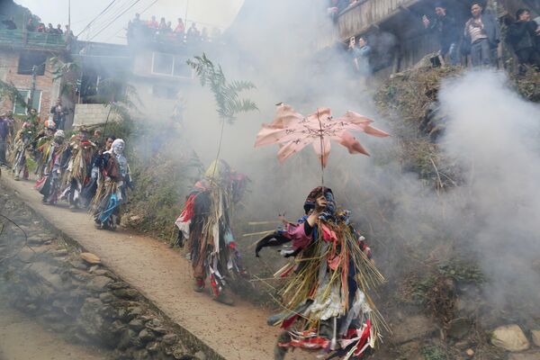 Сельские жители, одетые в костюмы горных божеств, принимают участие в шествии, раздавая хорошие пожелания во время празднования Нового года по лунному календарю, в деревне Мяо в Лючжоу, Гуанси-Чжуанский автономный район, Китай - Sputnik Грузия