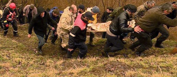 Спасатели и местные жители несут тело 14-летнего мальчика, который был найден в реке - Sputnik Грузия