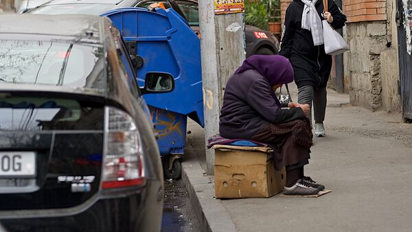 Попрошайка на одной из улиц просит милостыню у обменного пункта - Sputnik Грузия