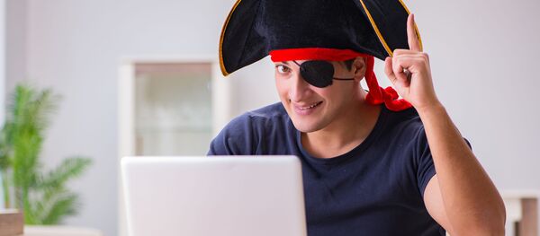 Молодой человек в шляпе пирата перед открытым ноутбуком Молодой человек в шляпе пирата перед открытым ноутбуком - Sputnik Грузия