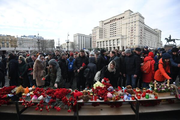 Люди возлагают цветы к мемориалу на Манежной площади в Москве в память о погибших в ТЦ Зимняя вишня в Кемерово - Sputnik Грузия