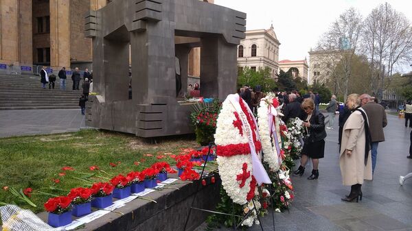 Люди у мемориала памяти жертв трагедии 9 апреля на проспекте Руставели у здания парламента - Sputnik Грузия