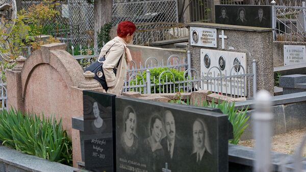 Женщина идет по Кукийскому кладбищу среди могил - Sputnik Грузия