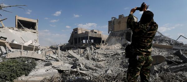 Солдат фотографирует разрушенный научно-исследовательский центр в Дамаске после бомардировки - Sputnik Грузия