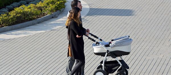 Молодые родители гуляют с ребенком в коляске - Sputnik Грузия