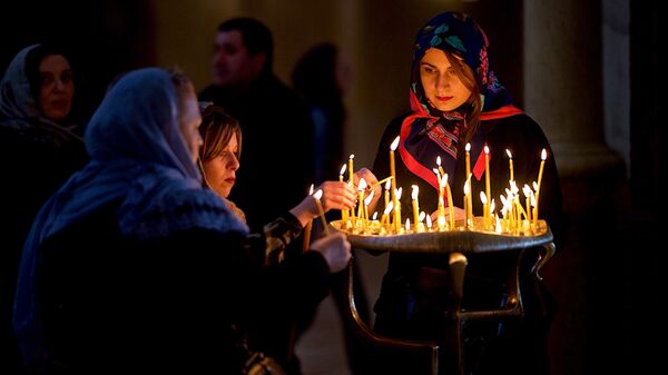 Верующие ставят свечки в церкви перед иконой Богородицы - Sputnik Грузия
