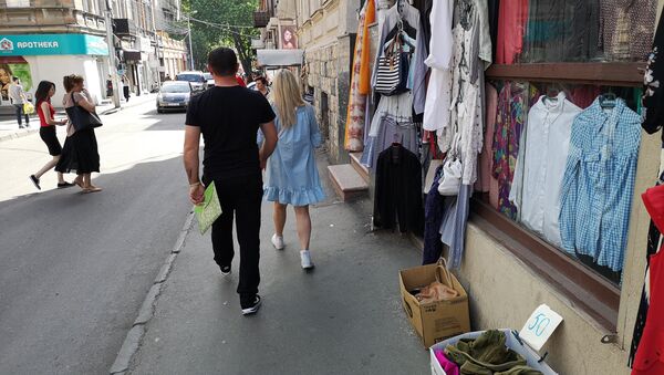 Люди идут по улице мимо магазинов подержанной одежды в районе метро Марджанишвили - Sputnik Грузия