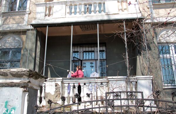 Центр города. Женщина развешивает белье на балконе старинной усадьбы. - Sputnik Грузия