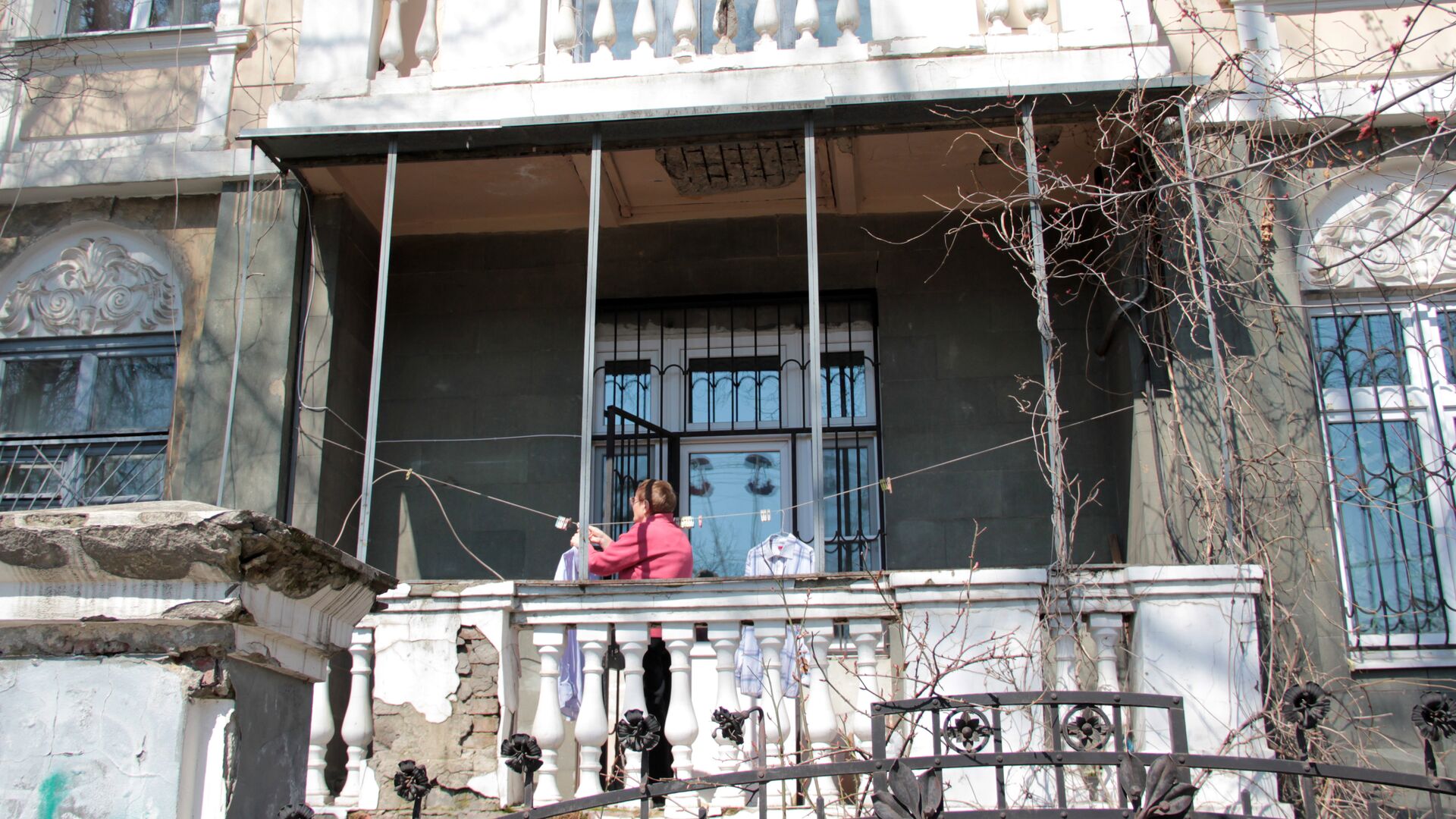 Центр города. Женщина развешивает белье на балконе старинной усадьбы. - Sputnik Грузия, 1920, 22.08.2021