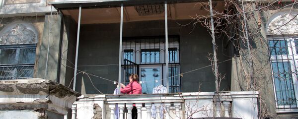 Центр города. Женщина развешивает белье на балконе старинной усадьбы. Центр города. Женщина развешивает белье на балконе старинной усадьбы. - Sputnik Грузия