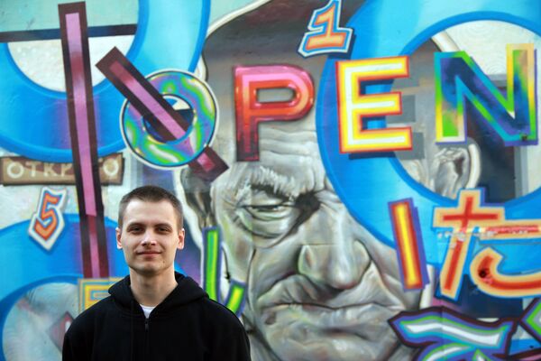 Никита Nomerz - уличный художник и организатор нижегородского  арт-проекта “Место”, фотографируется на фоне одной из своих работ - Sputnik Грузия
