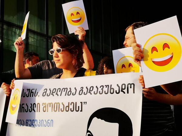 Участники акции держали в руках плакаты с разными лозунгами, а также изображения смайликов - Sputnik Грузия