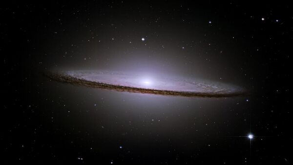 Вид галактики M104 напоминает шляпу, поэтому ее и назвали галактикой Сомбреро. На картинке видны отчетливые темные полосы пыли и яркое гало из звезд и шаровых скоплений. Причины, по которым галактика Сомбреро похожа на шляпу – необычно большой центральный звездный балдж и плотные темные полосы пыли, находящиеся в диске галактики, который мы видим почти с ребра. Диффузное свечение протяженного центрального балджа создают миллиарды старых звезд - Sputnik Грузия