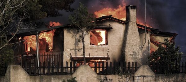 Горящий дом, попавший в зону лесных пожаров в окрестностях Афин, Греция - Sputnik Грузия