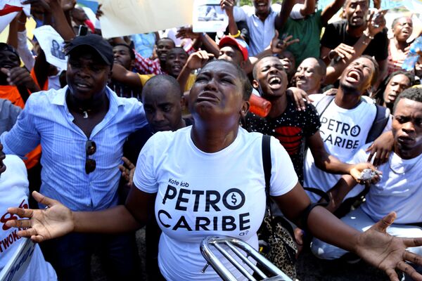 Гаитяне протестуют с призывом к расследованию деятельности представителей властных структур, которых обвиняют в финансовых злоупотреблениях. О злоупотреблениях бывших чиновников сообщил фонд PetroCaribe. Акции проходят в Порт-о-Пренсе, Гаити - Sputnik Грузия