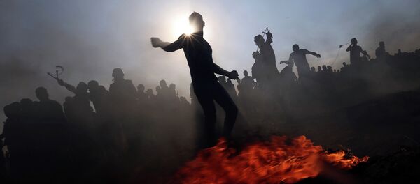 Палестинские демонстранты бросают камни в израильские войска во время акции протеста в южном Секторе Газа Палестинские демонстранты бросают камни в израильские войска во время акции протеста в южном Секторе Газа - Sputnik Грузия