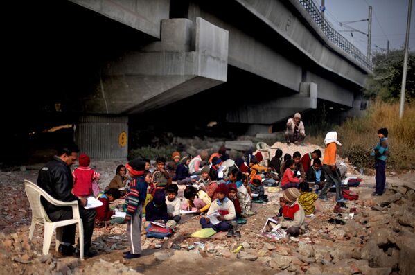 Школа под железнодорожным мостом в Индии была организована волонтерами специально для детей из беднейших семей. Она расположена под одной из эстакад Нью-Дели. В школе детей обучают азам счета, чтения и английского языка. Школа для детей под открытым небом - единственная надежда на их лучшую жизнь - Sputnik Грузия