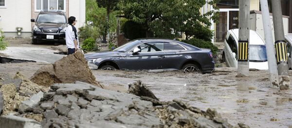 Люди смотрят на последствия сильного землетрясения в Японии - Sputnik Грузия