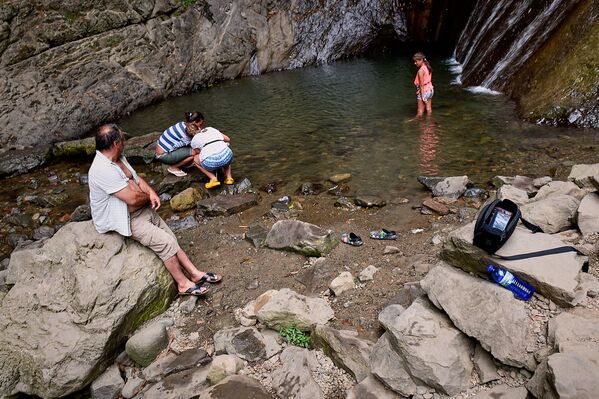 В жаркую погоду немало людей приходит к водопаду в купальных костюмах, чтобы окунуться в ледяную воду - Sputnik Грузия