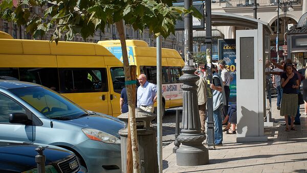 Желтые маршрутные такси у автобусной остановки, где люди ждут транспорт - Sputnik Грузия
