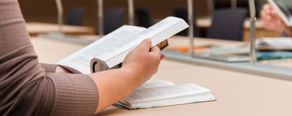 Девушка читает книгу в библиотеке - Sputnik Грузия