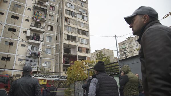 Местные жители смотрят на жилой дом в Поничала, часть которого была разрушена в результате взрыва - Sputnik Грузия