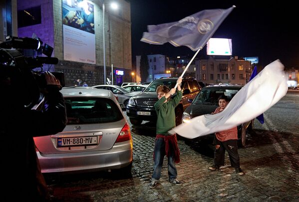 Машины и люди с флагами проезжали и проходили мимо штаба Саломе Зурабишвили, где собрались десятки журналистов после завершения голосования  - Sputnik Грузия