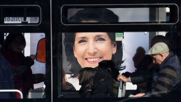Люди на фоне предвыборного баннера Саломе Зурабишвили - Sputnik Грузия