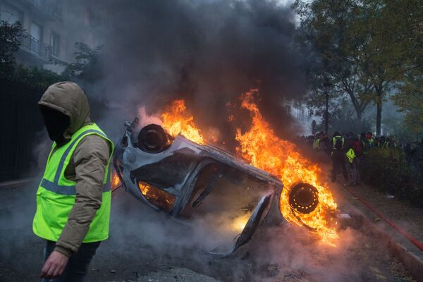 Горящий автомобиль, который подожгли во время протестной акции движения автомобилистов Желтые жилеты в Париже. В ходе акции протеста желтых жилетов в Париже были задержаны более 260 человек - Sputnik Грузия