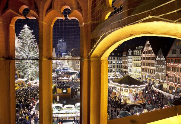 В рождественские праздники на франкфуртской площади Рёмерберг пахнет булочками с марципаном и картофельными блинчиками под сладким соусом. Кружка яблочного вина здесь действует, как эликсир молодости: через пять минут вы уже кружитесь на карусели под колокольный звон - Sputnik Грузия