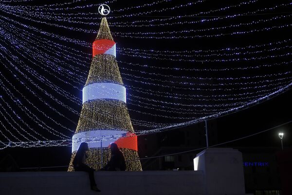 Две девушки у рождественской ели на площади Сальвадора-дель-Мундо в Сан-Сальвадоре - Sputnik Грузия
