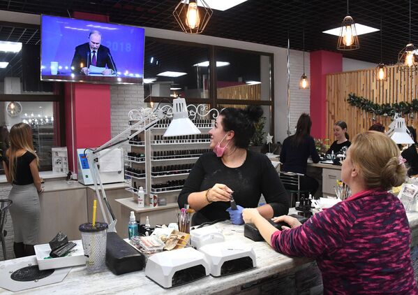 Женщины смотрят прямую трансляцию ежегодной большой пресс-конференции президента РФ Владимира Путина в салоне красоты во Владивостоке - Sputnik Грузия