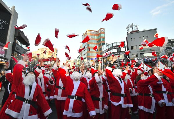 Волонтеры в костюмах Санта-Клауса до раздачи подарков бедным семьям в Сеуле  - Sputnik Грузия