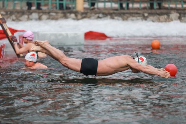 Мужчина во время зимних соревнований по плаванию при температуре -21 градус по Цельсию в Шэньяне, провинция Ляонин на северо-востоке Китая - Sputnik Грузия