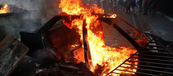 Горящий автомобиль баррикадах во время протестов в Каракасе, Венесуэла Горящий автомобиль баррикадах во время протестов в Каракасе, Венесуэла - Sputnik Грузия