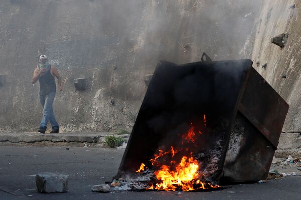 Демонстранты в Каракасе во время столкновений с полицией используют защитные сооружения и баррикады - Sputnik Грузия