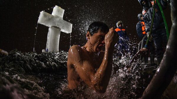 Мужчина во время традиционных купаний в праздник Крещения у храма Живоначальной Троицы в поселке Норское - Sputnik Грузия