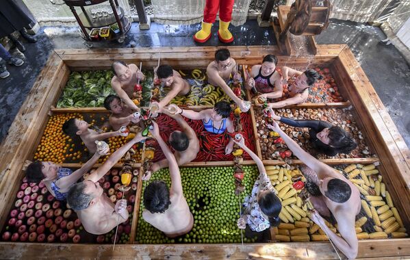 Постояльцы отеля в китайском городе Ханчжоу проводят время в теплом бассейне, наполненном фруктами и овощами, в предверии Китайского Нового года - Sputnik Грузия