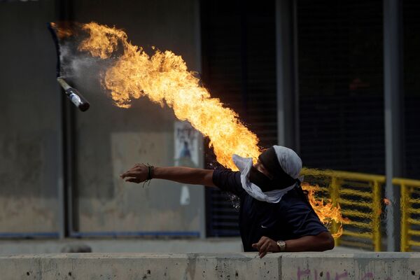 Демонстрант кидает бутылку с зажигательной смесью во время протестов против президента Гондураса Хуана Орландо Эрнандеса в Тегусигальпе - Sputnik Грузия