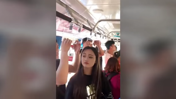 Невысокая девушка решила проблему высоких поручней в автобусе – забавное видео - Sputnik Грузия
