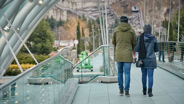 Парень и девушка. Туристы гуляют по мосту Мира - Sputnik Грузия