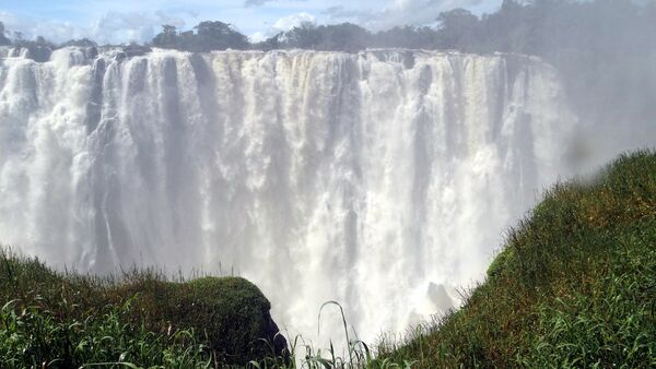 Водопад Виктория - потрясающий природный феномен, находится на реке Замбези на границе Замбии и Зимбабве. Водопад чрезвычайно широк - приблизительно 1,8 километра в ширину. Высота падения воды изменяется от 80 метров у правого берега водопада до 108 метров в центре - Sputnik Грузия