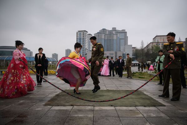 ახალდაქორწინებულები ლახტზე ხტუნაობენ საქორწილო ფოტოსესიის დროს ფხენიანში, ჩრდილოეთ კორეა - Sputnik საქართველო