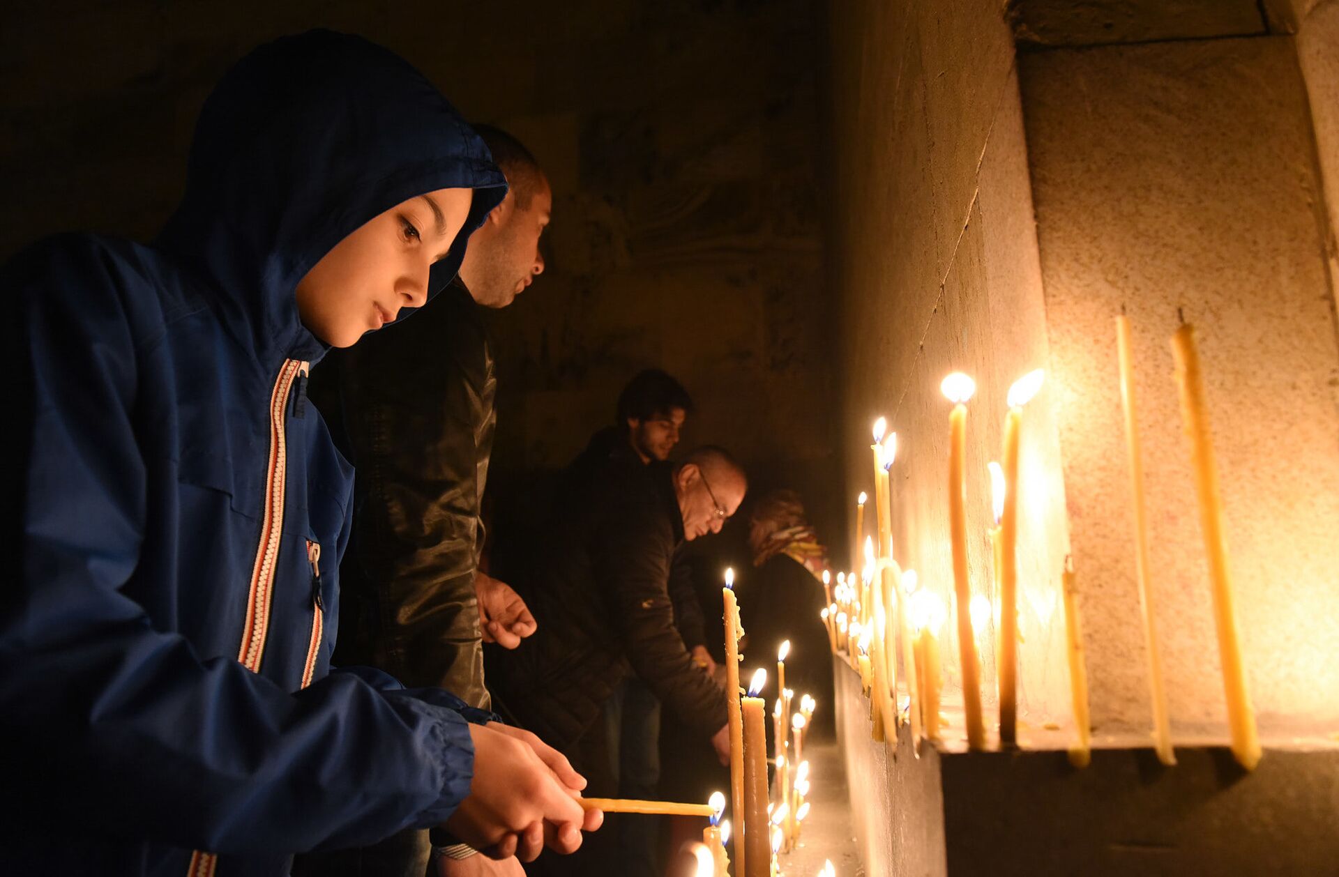 Верующие зажигают свечи во время Пасхального богослужения у стен храма Святой Троицы - Sputnik Грузия, 1920, 24.08.2021